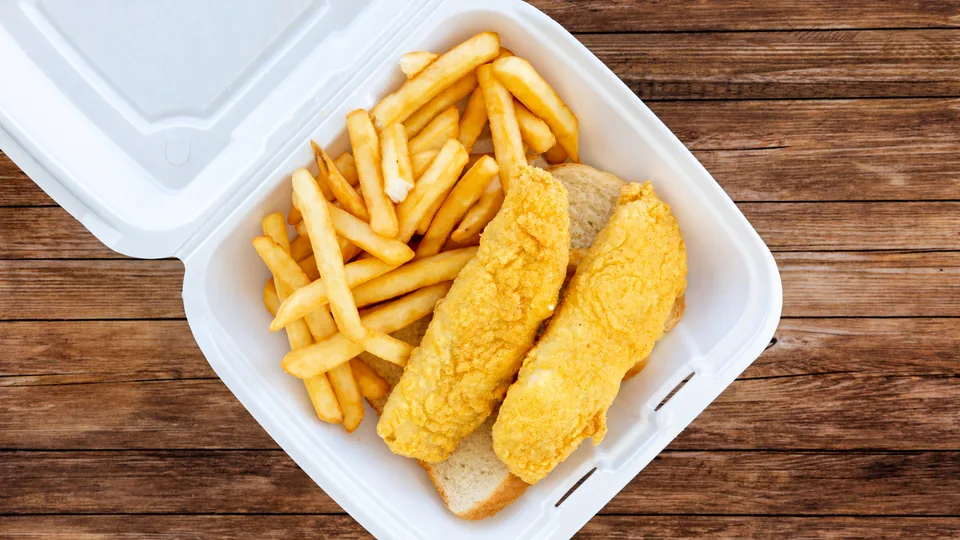 Two breaded fish fillets with fries